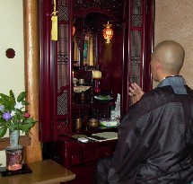 家庭訪問して仏壇の前で読経する日本の僧侶
